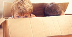 Two kids playing in a box.