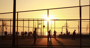 image of basketball players on outdoorcourt at sunset