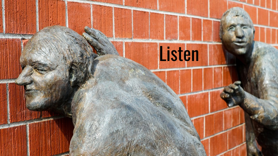 image of sculptures listening to a brick wall